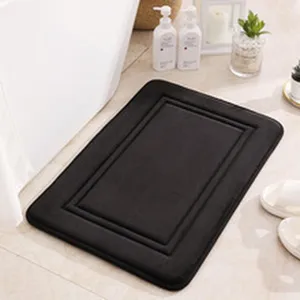 Black bathroom floor mat with embossed border, soft anti-slip absorbent rug for home use.