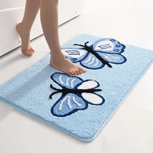 Alfombra de baño de felpa azul con detalle de mariposa, superficie suave y absorbente para aseo.