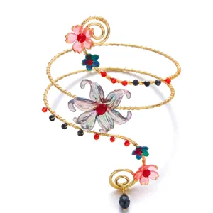 Vista detallada del brazalete superior dorado hecho a mano con flores coloridas.