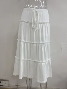 White tiered maxi skirt featuring an elastic drawstring waist and ruffled patchwork details.
