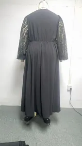 Details of the elegant black long dress featuring delicate lace sleeves and flowing fabric.
