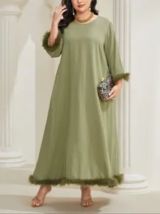 Dettaglio abito lungo verde oliva, con elegante finitura in pelliccia sintetica su polsini.
