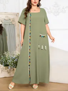 Vista detallada del vestido largo verde oliva de talla grande con borlas y bolsillo.
