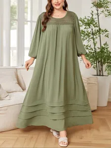 Detalle de vestido largo grande verde oliva, cuello de malla y dobladillo con capas.