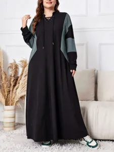 Détail de robe longue décontractée à capuche bloc de couleurs avec manches contrastées et style.