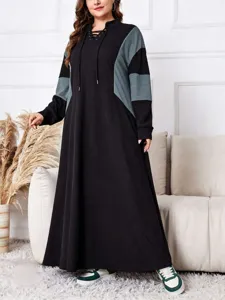Détail de robe longue ample grande taille à capuche, style color block confortable.