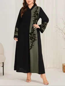 Dettaglio maxi abito maniche lunghe taglie forti, elegante veste nera ricamata con verde.