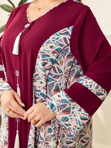 Primo piano della lunga vestito bordeaux da donna con stampa geometrica e scollo a V con nappe
