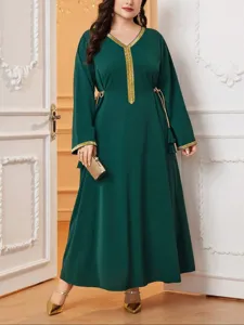 Vista dettagliata dell'abito lungo plus size verde scuro con elegante bordo dorato.