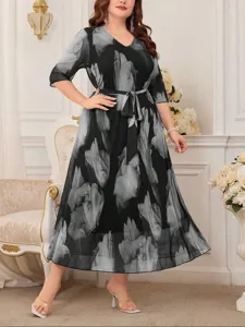 Abito lungo taglia forte nero e floreale con scollo a V, maniche 3/4 e cintura elegante.