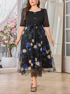 Vestido midi negro de talla grande con malla bordada de flores y cinturón elegante.
