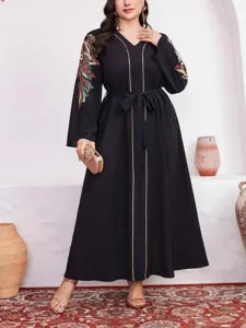 Dettagli squisiti di questo abito lungo nero plus size con ricami complessi sulle maniche.