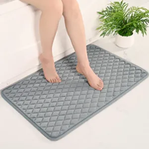 Vue détaillée du tapis de bain en mousse à mémoire gris avec motif losanges dans la salle de bain.