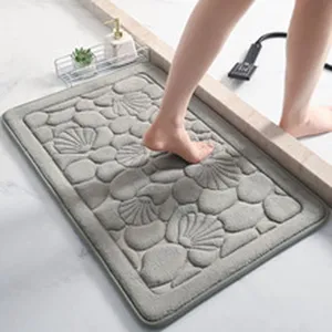 Tapis de bain gris avec motif en relief galet et coquillage, antidérapant et absorbant.