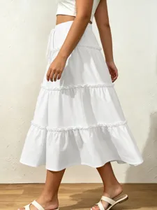 Detail view of a white tiered midi skirt featuring ruffle layers and elastic drawstring waist.