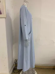 Detailed side view of the light blue casual long dress featuring roll-up sleeves and large pockets.