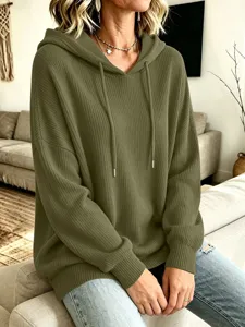 Nahaufnahme des Rippstrickgewebes und der Kapuze mit Kordelzug an diesem grünen Hoodie.
