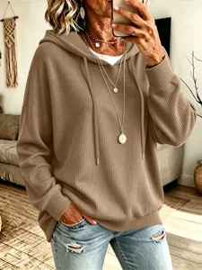 Lässiger Strick-Kapuzenpullover Detailansicht mit lockerer Textur und praktischem Kordelzug.
