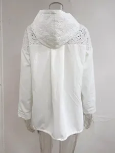 Détail de veste anti-soleil à capuche en dentelle blanche avec crochet et cordon.