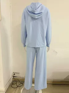 Casual light blue two-piece tracksuit featuring a loose hooded sweatshirt and wide-leg pants.