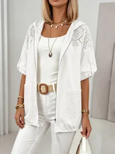 Détail de veste courte à capuche en dentelle blanche avec crochet ajouré et fermeture éclair.