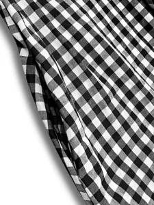 Close-up detail shot of black and white gingham plaid dress fabric with pocket design.