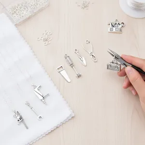 Detailed view of antique silver hardware tool charms, miniature pendants for DIY jewelry.