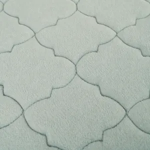Thickened coral fleece floor mat with embossed quatrefoil pattern for home living room.