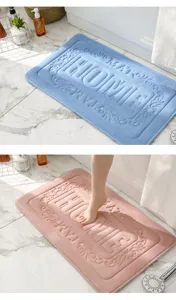 Dettaglio tappeto bagno memory foam, superficie vellutata con scritta HOME in rilievo.