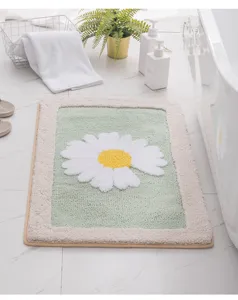 Close-up detail of the fluffy green and white floral bath mat with daisy pattern in modern bath.