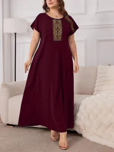 Detailed view of the elegant plus-size maxi dress featuring intricate golden embroidery.