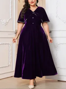 Deep purple velvet dress detail, featuring V-neck, cape collar and sparkling rhinestone trim.