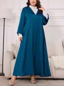 Vista di dettaglio di un abito lungo oversize con maniche lunghe e cappuccio, elegante.
