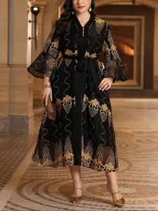 Vista dettagliata di un elegante abito lungo nero plus size con intricati ricami dorati.