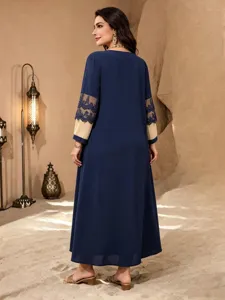 Detailansicht des dunkelblauen Langarm-Maxikleids mit eleganten Spitzenärmel-Einsätzen.