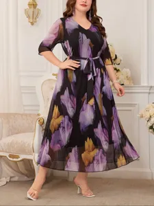 Dettaglio dell'abito midi plus size con stampa floreale, scollo a V e cintura in vita.