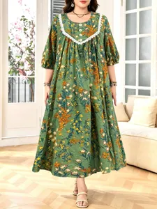 Nahaufnahme des eleganten grünen Blumen-Maxikleids mit feiner Spitzenborte und weichem Stoff.
