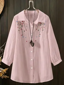 Plus size pink pleated long sleeve blouse featuring delicate floral embroidery and lapel collar.