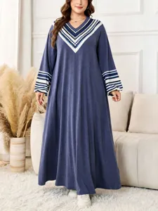 Plus size long sleeve maxi dress featuring geometric V-neck and stylish striped cuffs.