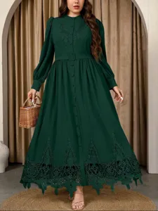 Elegant dark green plus-size long sleeve embroidered maxi dress detail view in studio.