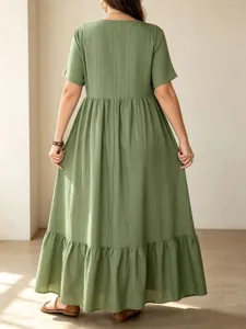 Detailed back view of a casual green maxi dress with tiered hem and short sleeves, elegant.
