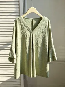Detail of the elegant plus size V-neck top with floral jacquard and layered sleeves.