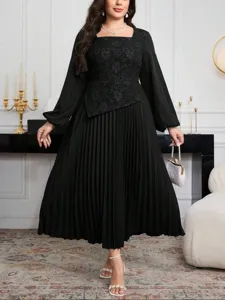 Detailed view of black plus size long sleeve pleated dress with floral bodice details.