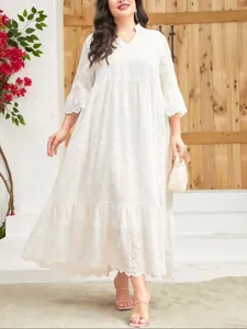 Detailed view of the elegant white plus-size maxi dress with eyelet lace embroidery and tiered hem.