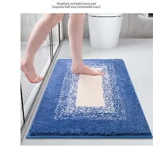 Detail of plush absorbent bath mat in blue gradient, soft fluffy texture for bathroom floor use.