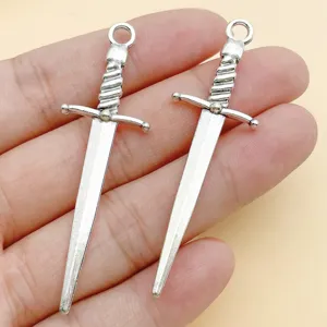 Close-up of antique silver sword pendants charms for DIY jewelry making necklaces bracelets.