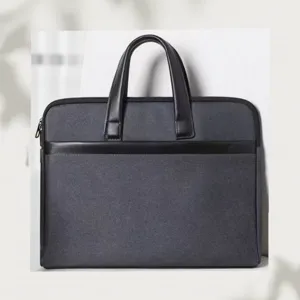 Dettaglio della borsa per laptop grigia scura con manici in elegante pelle nera.