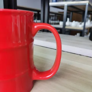 Detaillierte Nahaufnahme des kreativen oeltonnenfoermigen roten Keramik Kaffeetassen-Griffs.