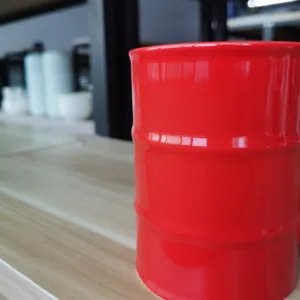 Nahaufnahme einer kreativen roten Keramiktasse im Ölfass-Design mit glatter Glasurstruktur.