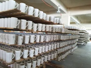 Keramik Kaffeetassen im Großlager Regal Display, weiße Porzellanbecher mit einfachen Kreuz.